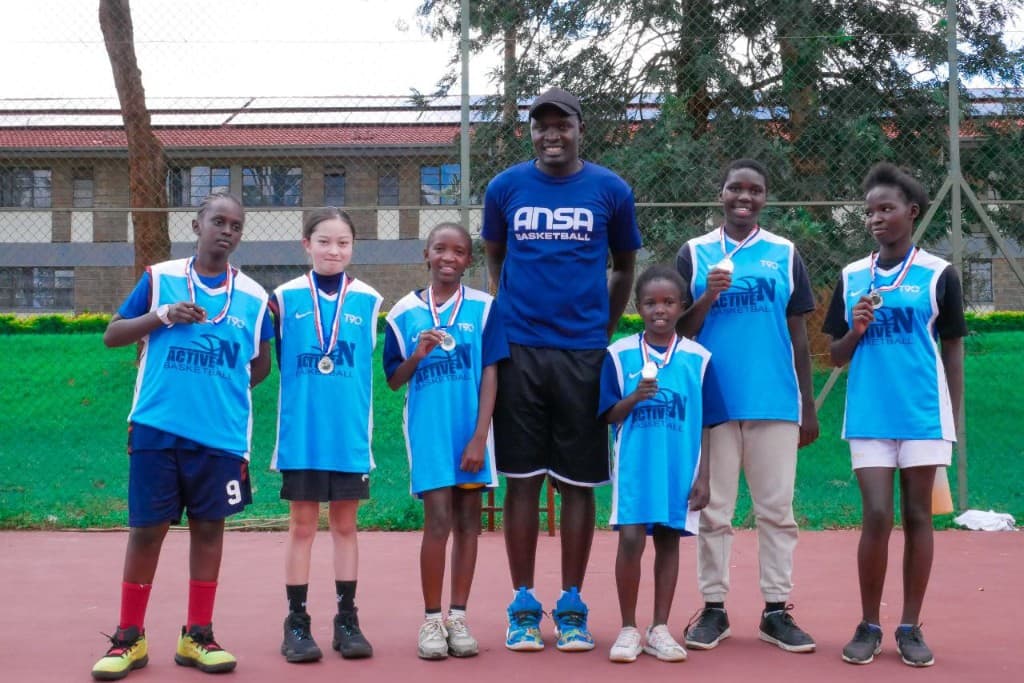 ANSA Basketball coach with young players wearing medals